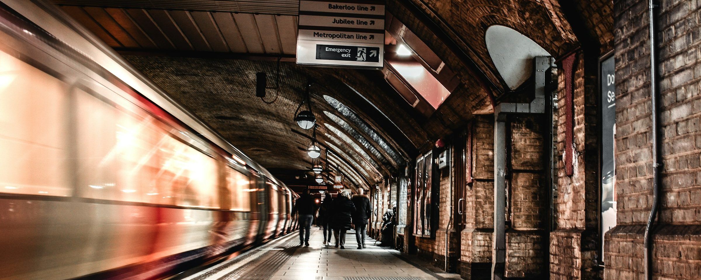A train speeding past a brick-lined Underground platform